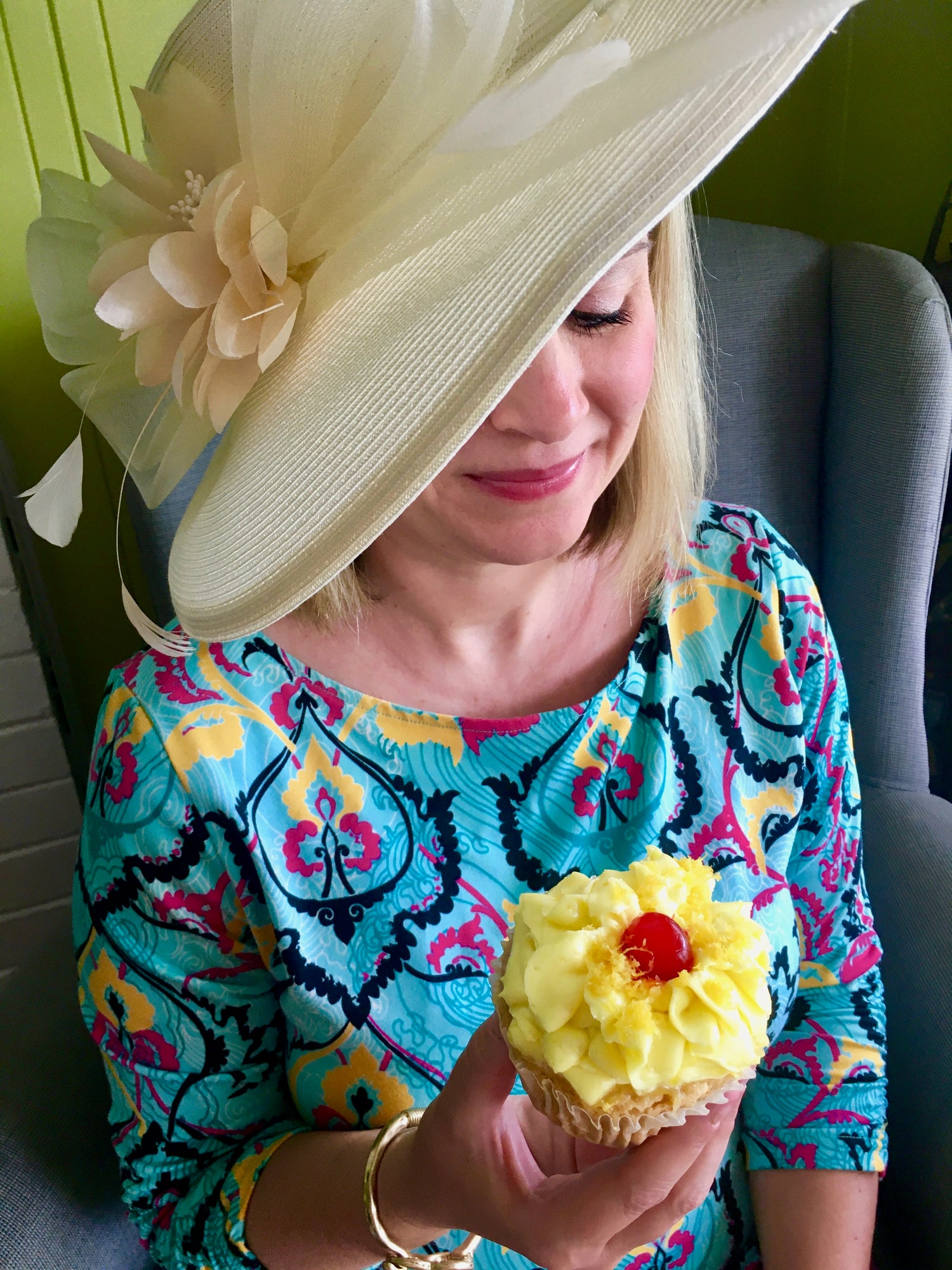 inebriated baker woman holding lemon drop martini cupcake